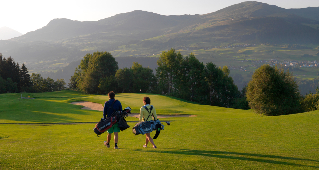 Das Foto zeigt zwei Golfer die auf dem Platz sind Das Foto zeigt zwei Golfer die auf dem Platz sind