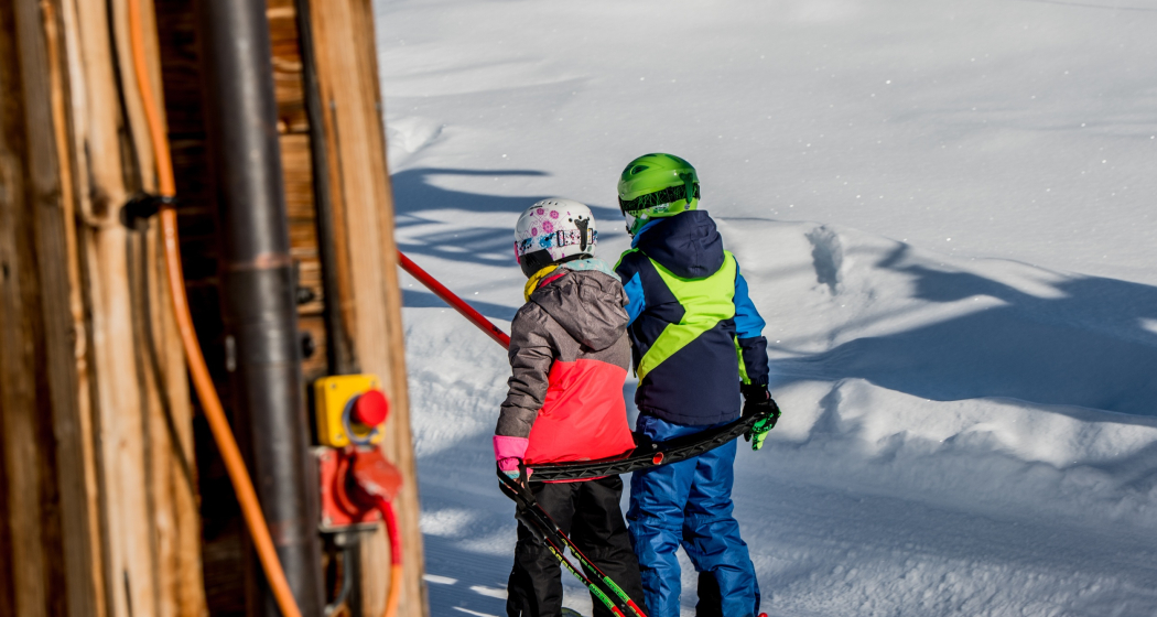 Das Foto zeigt zwei junge Kinder die auf dem Skilift Parli eingestiegen sind Das Foto zeigt zwei junge Kinder die auf dem Skilift Parli eingestiegen sind