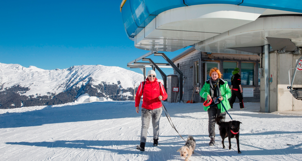 Das Foto zeigt zwei Frauen die mit Hunden auf der Bergstation aussteigen Das Foto zeigt zwei Frauen die mit Hunden auf der Bergstation aussteigen